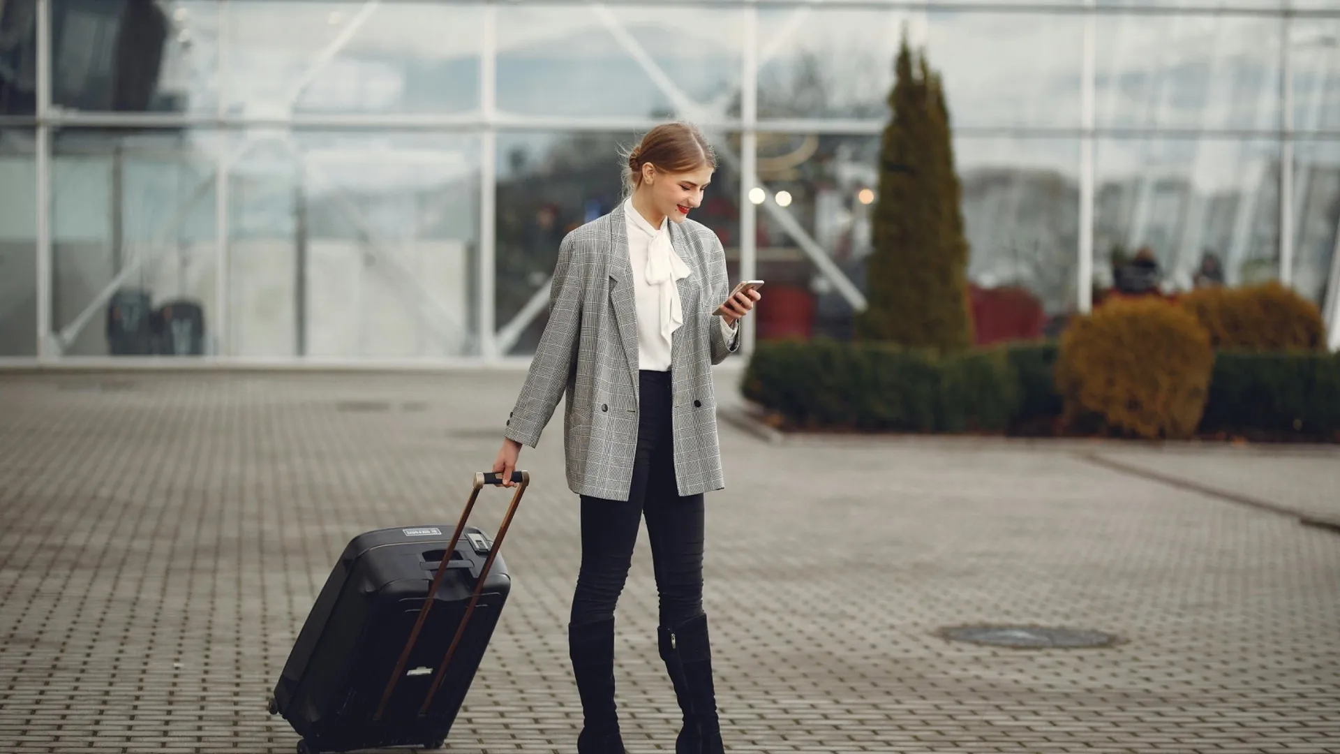Traveler outside terminal using smartphone